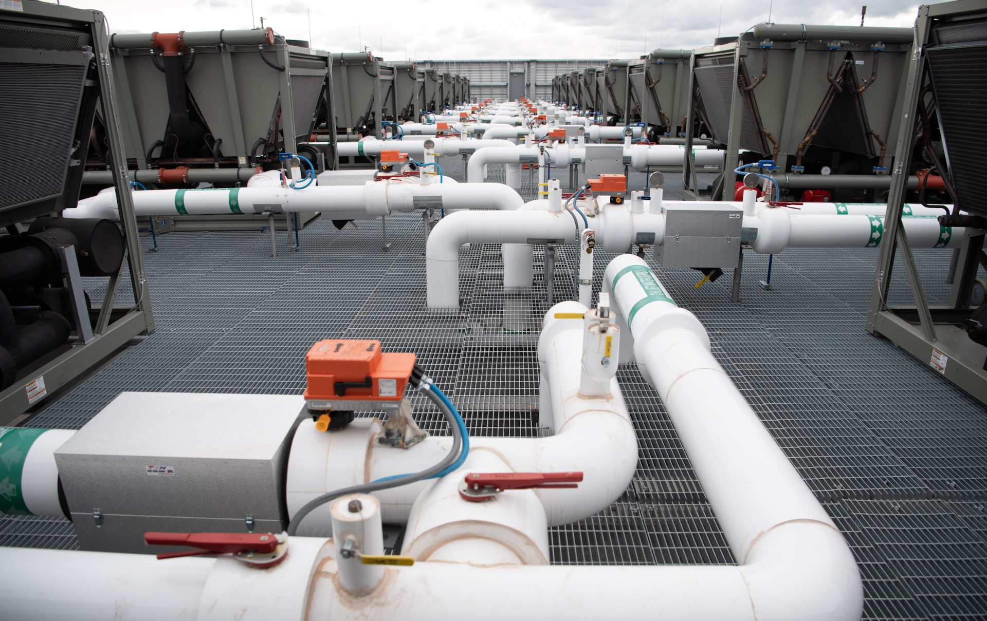 Rooftop cooling equipment with rows of insulated white pipes